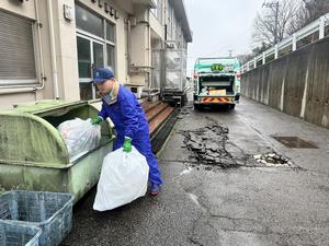 傷んだアスファルトで収集車が停められない様子