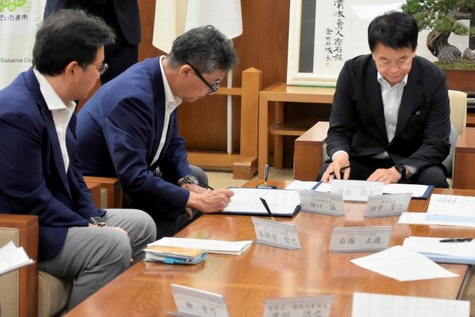 締結式で覚書に署名する様子