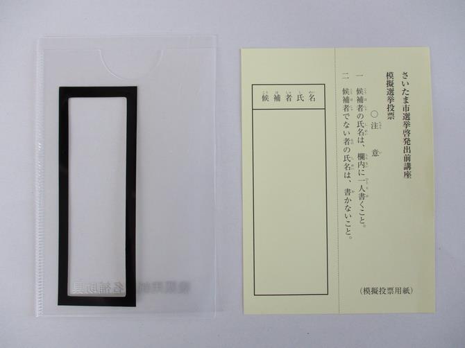 投票用紙記入補助具と投票用紙を並べた写真
