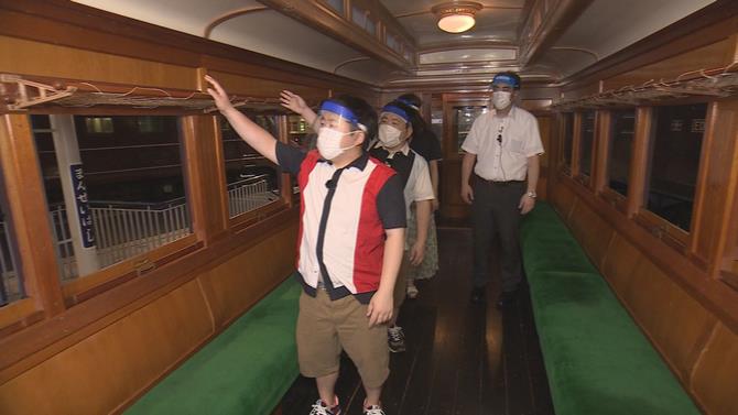 電車の中にいる出演者の写真