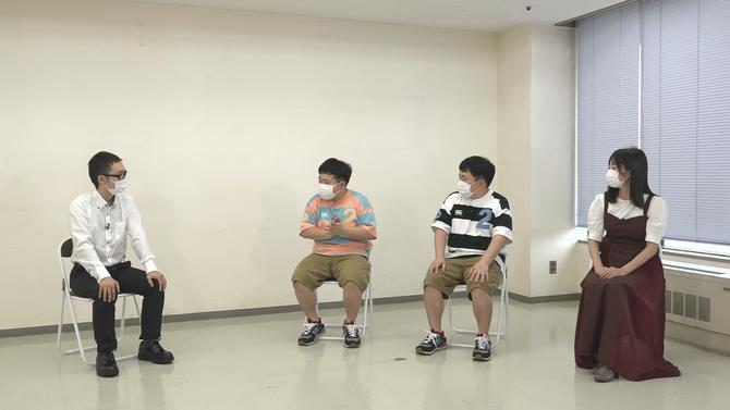 職員から説明を受ける出演者の写真