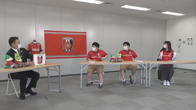 浦和レッズの説明をうける出演者の写真