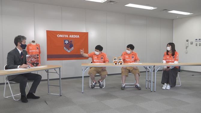 大宮アルディージャの説明をうける出演者の写真