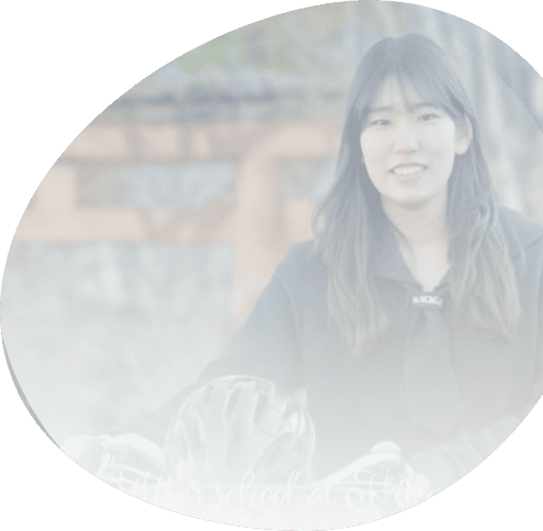 屋外で黒い服を着た女性が自転車用ヘルメットを持ち、やわらかな光に包まれて写る円形写真