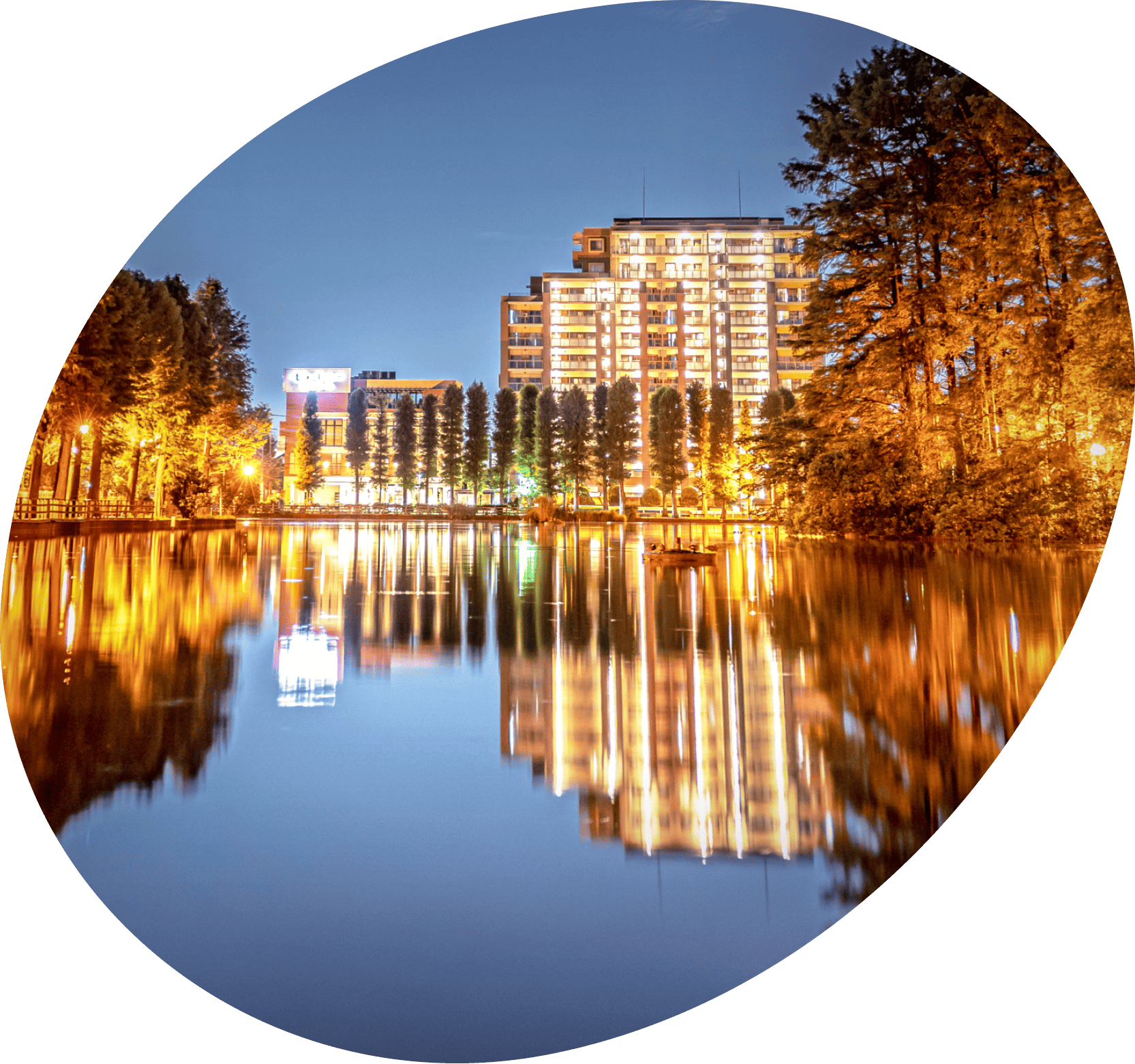 夜の川沿いにライトアップされた高層マンションや街並みが並び、水面に美しく反射している風景写真